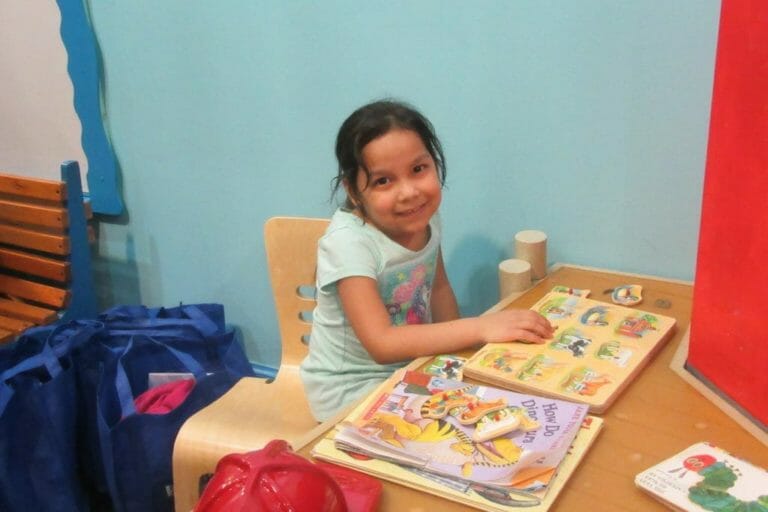 child seated playing with blocks.