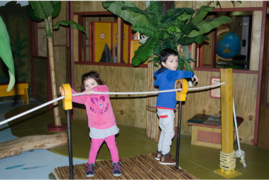 Two children pulling a rope across a bridge within our Great Explorations exhibit.