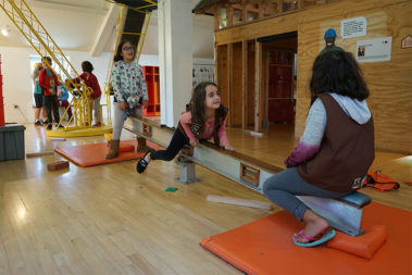 Children on a seesaw within our House About It exhibit.