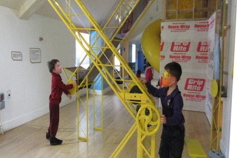 children playing with conveyor belt in House About It exhibit