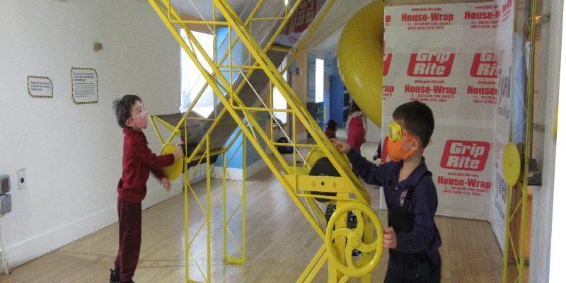 Outdoor Explorers boys with conveyer belt formatted for web children playing with conveyor belt in House About It exhibit