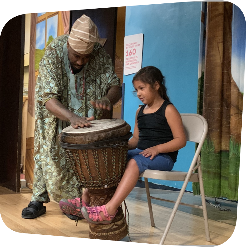 child seated while man plays drums