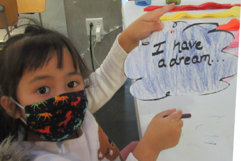Child holding up 'I have a dream' sign