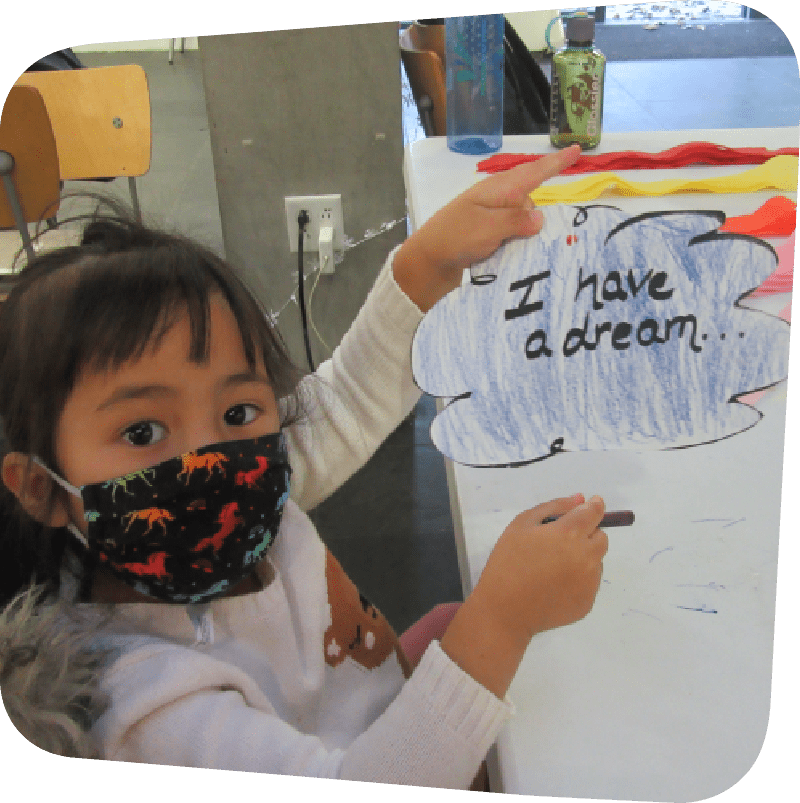 Child holding up 'I have a dream' sign