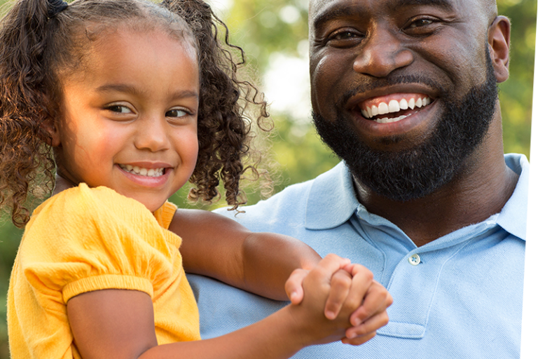 smiling father with smiling child in his arms