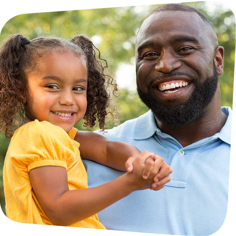 smiling father with smiling child in his arms