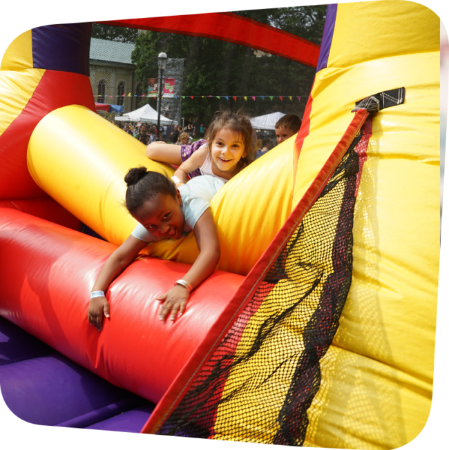 bouncehouse childrens laughing as they tumble out of a bounce house