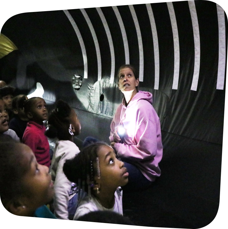 children and a teacher sitting inside an inflatable whale