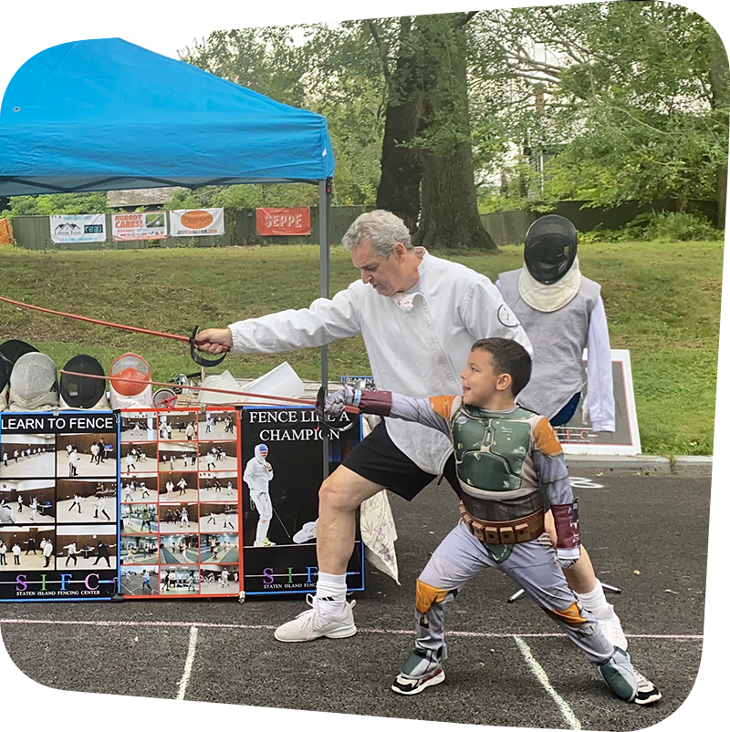 man demonstrating fencing to a young boy