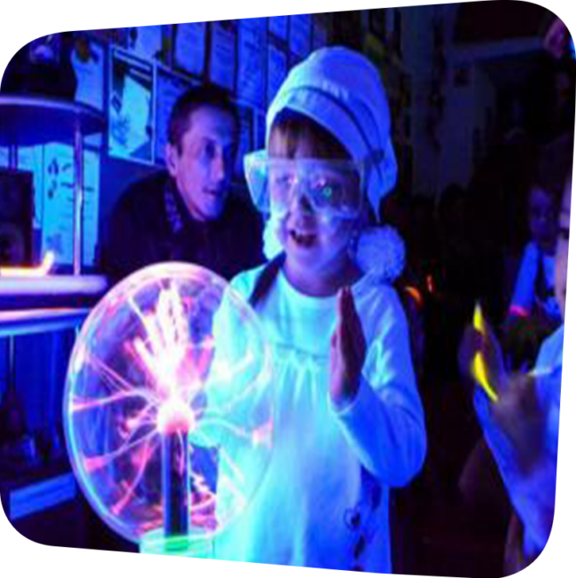 child with safety goggles touching a glowing ball of electricity