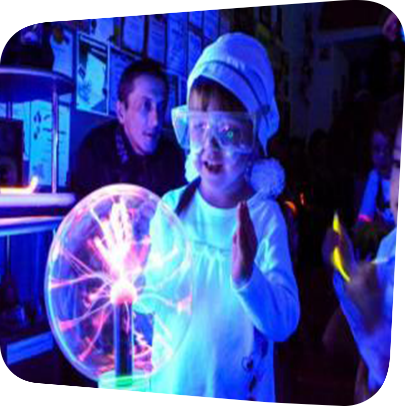 child with safety goggles touching a glowing ball of electricity