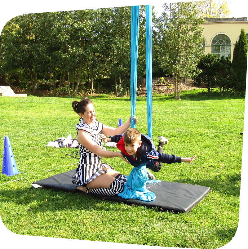 acrobat helping child visitor balance in her rig