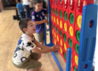 Two happy boys joyfully playing with the Connect Four components in the big play room.