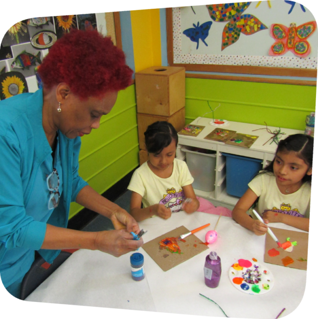Dr. Greene showing two girls art technique