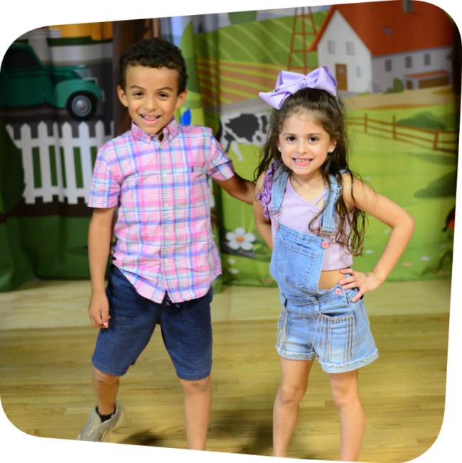 Two kids standing on stage in Portia's Playhouse