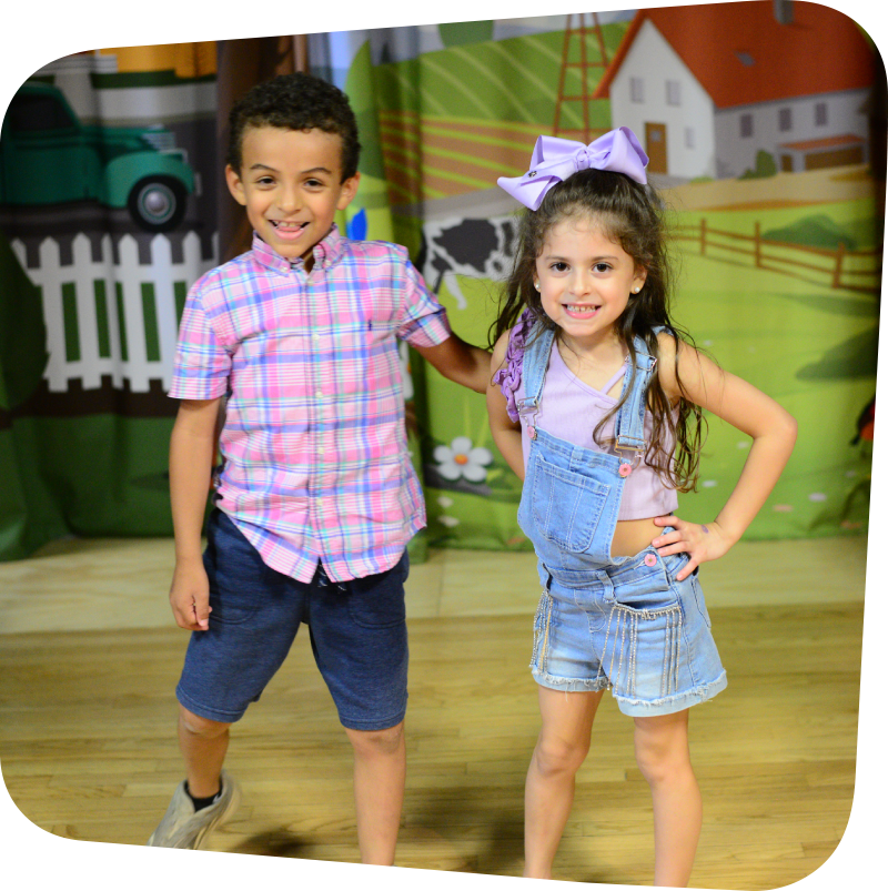Two kids standing on stage in Portia's Playhouse