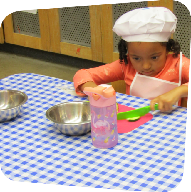 girl chopping veggies in classroom