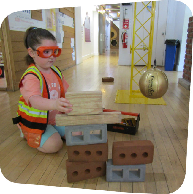 little girl in construction zone building with rubber bricks