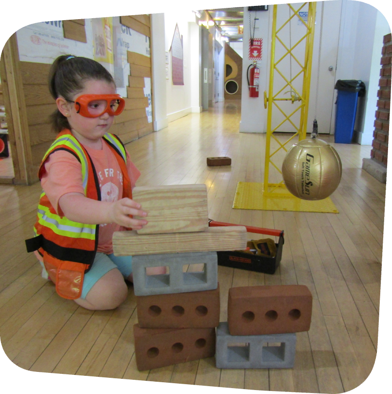 little girl in construction zone building with rubber bricks