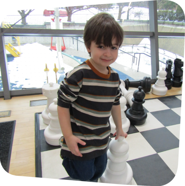 boy in big games playing chess