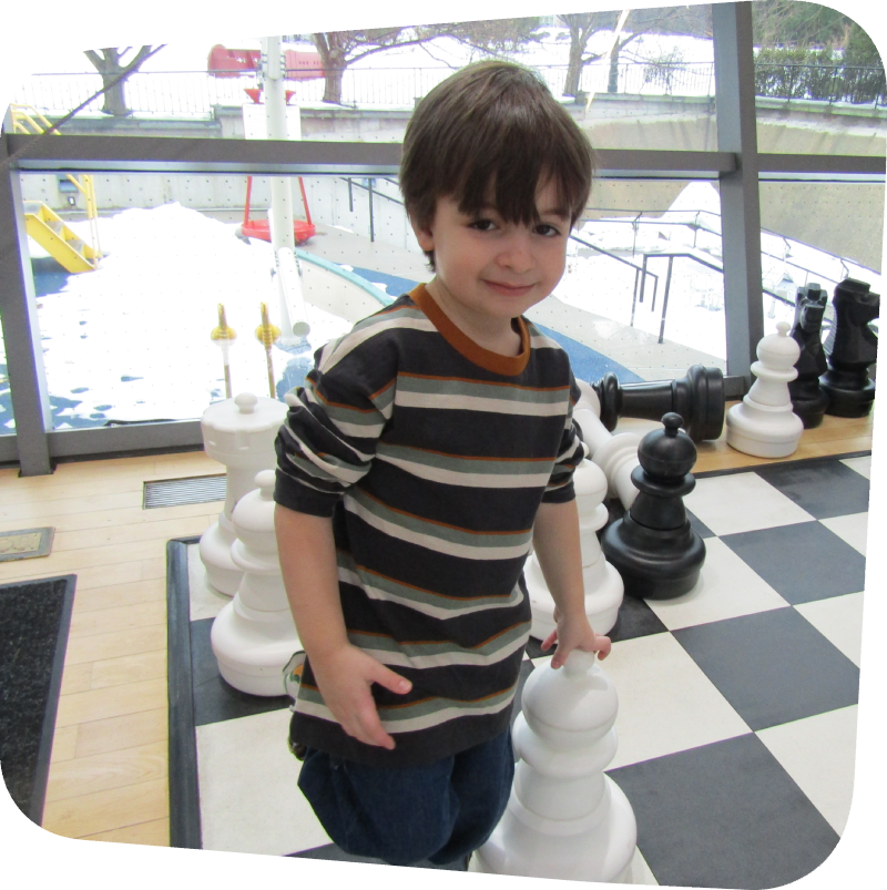 boy in big games playing chess