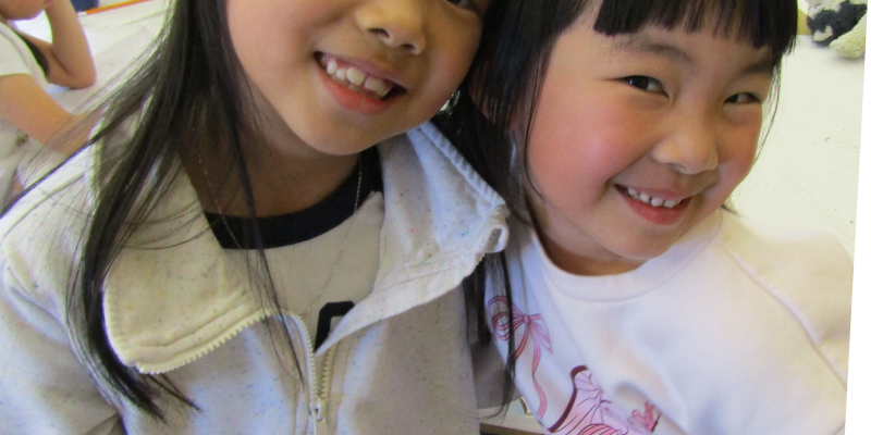 two girls smiling and hugging in the art classroom at the Staten Island Children's Museum