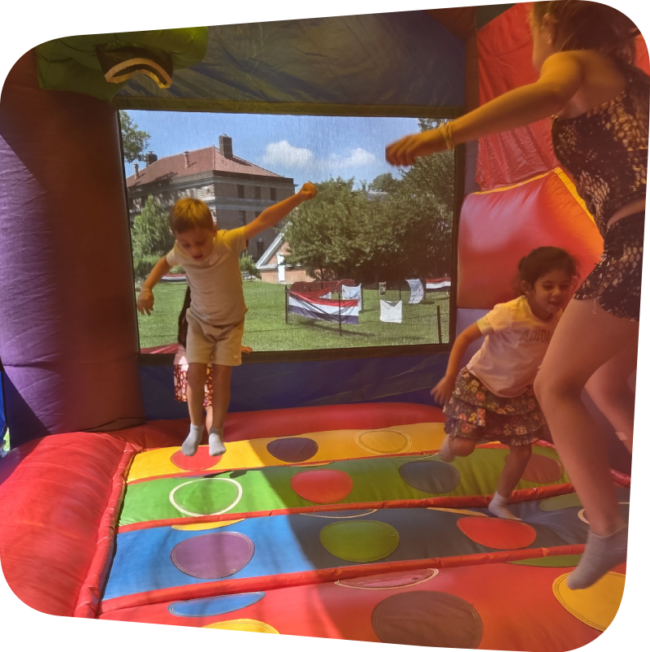 BH rhombus kids jumping in a bounce house in the meadow at the Staten Island Children's Museum