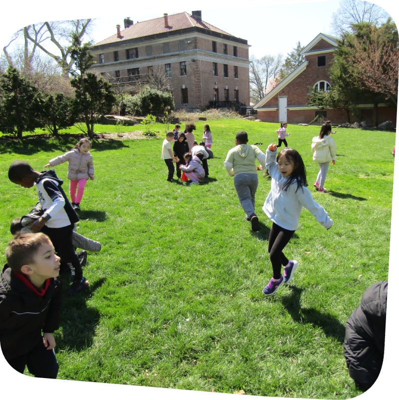 happy kids running in the field outside the Staten island Children's Museum