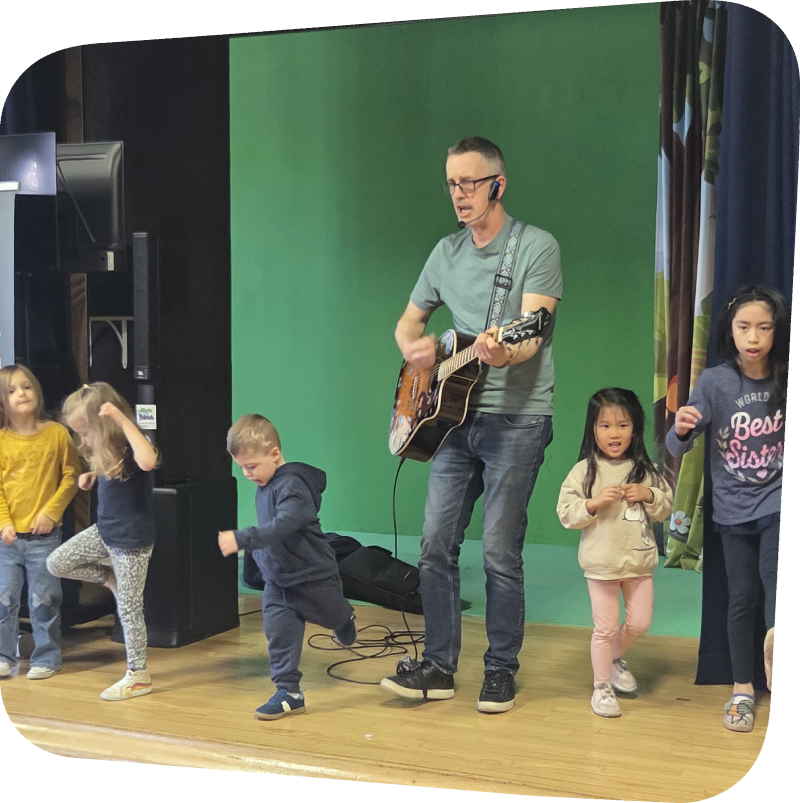 kids dancing on stage at the Staten Island Children's Museum to Mr. Patrick who is playing a guitar