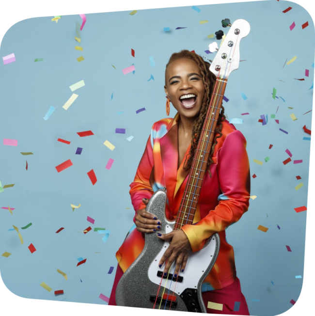 Divi Roxx Kids holding a bass guitar with confetti falling around her