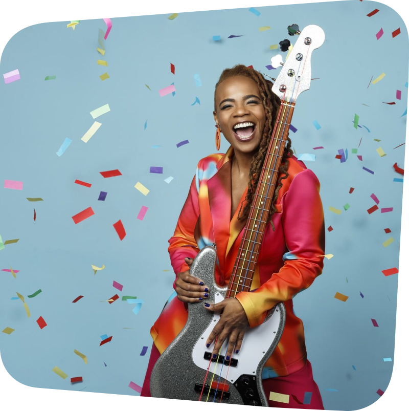 Divi Roxx Kids holding a bass guitar with confetti falling around her