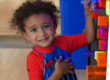smiling boy playing at the light bright in big games t the Staten Island Children's Museum