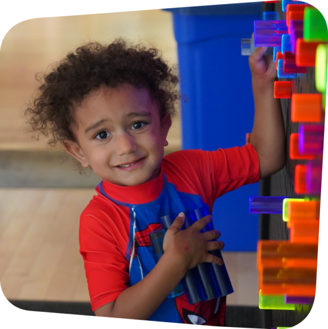 smiling boy playing at the light bright in big games t the Staten Island Children's Museum