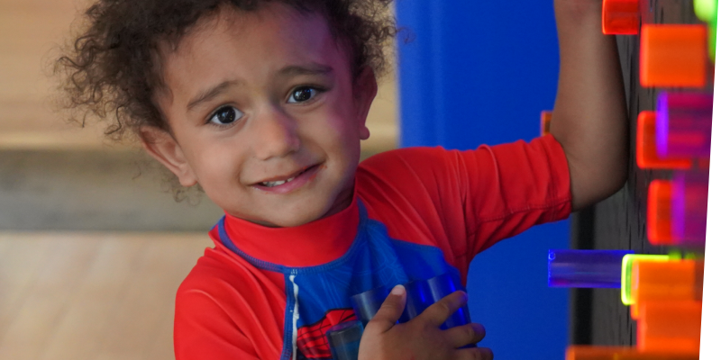 smiling boy playing at the light bright in big games t the Staten Island Children's Museum