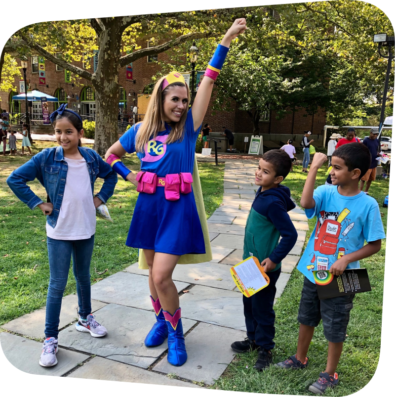Ready Girl with her arm up standing next to three smiling kids in front of the Staten island Children's Museum