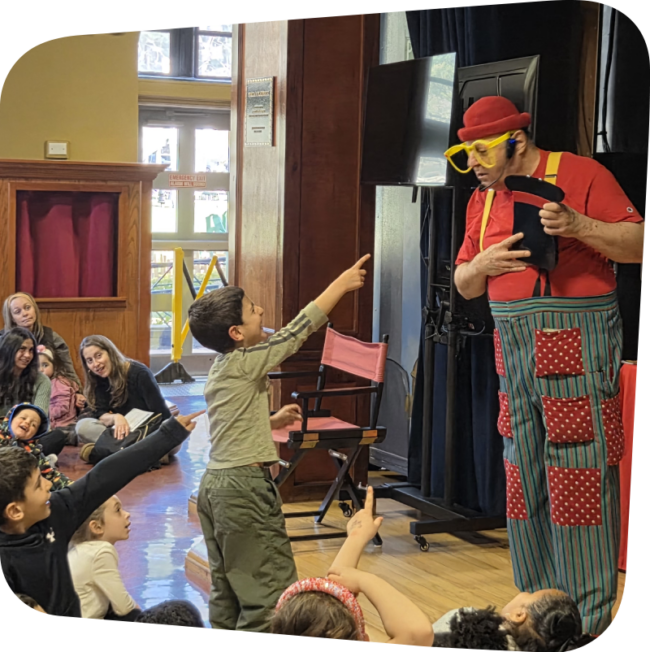 Silly billy performing on stage at the Staten Island Children's Museum with kids watching and laughing