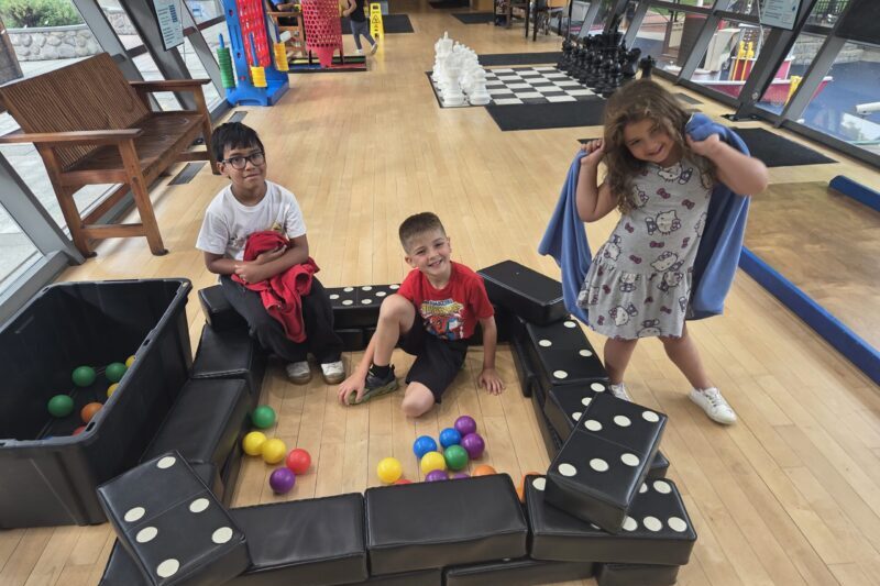 9093 three kids playing in Big Games exhibit