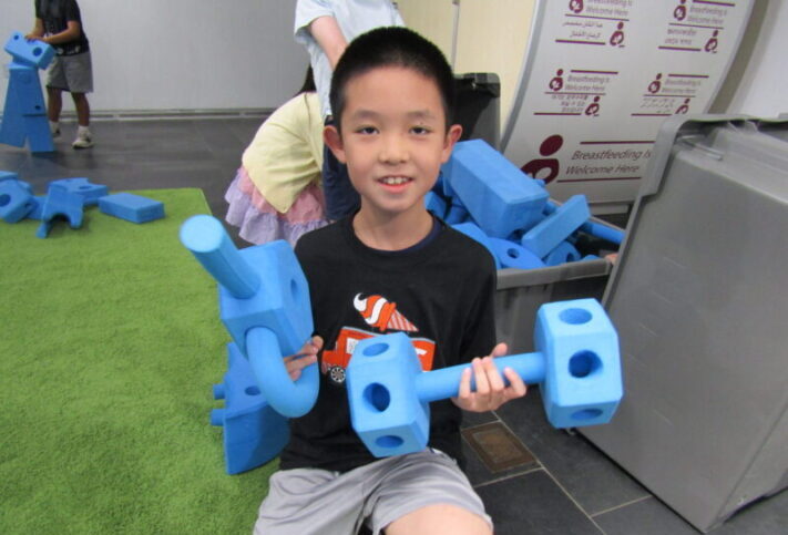 smiling boy playing with the blue foam pieces at the Staten Island Children's Museum