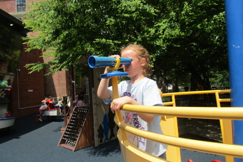 girl looking through the looking scope in the sea of boats exhibits