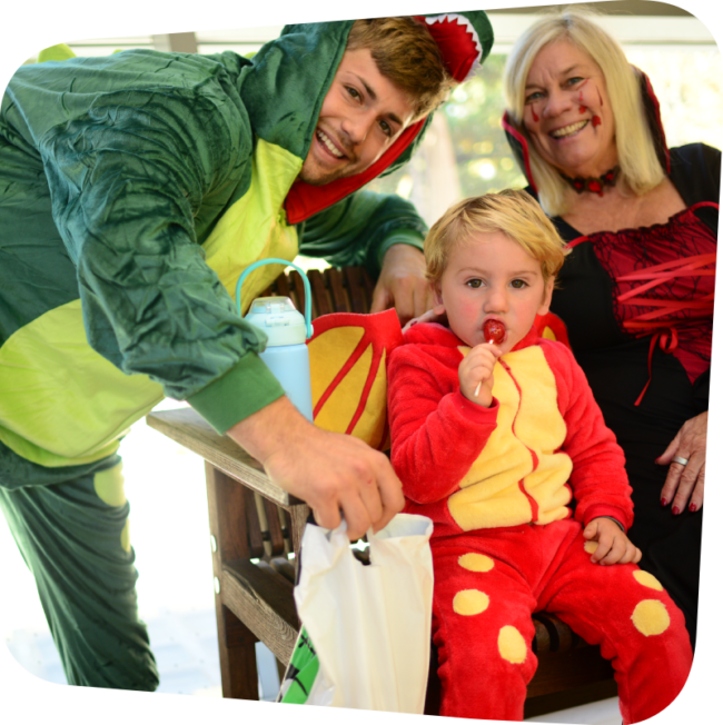 family dressed in halloween costumes with a little boy eating a lollipop at the Staten Island Children's Museum