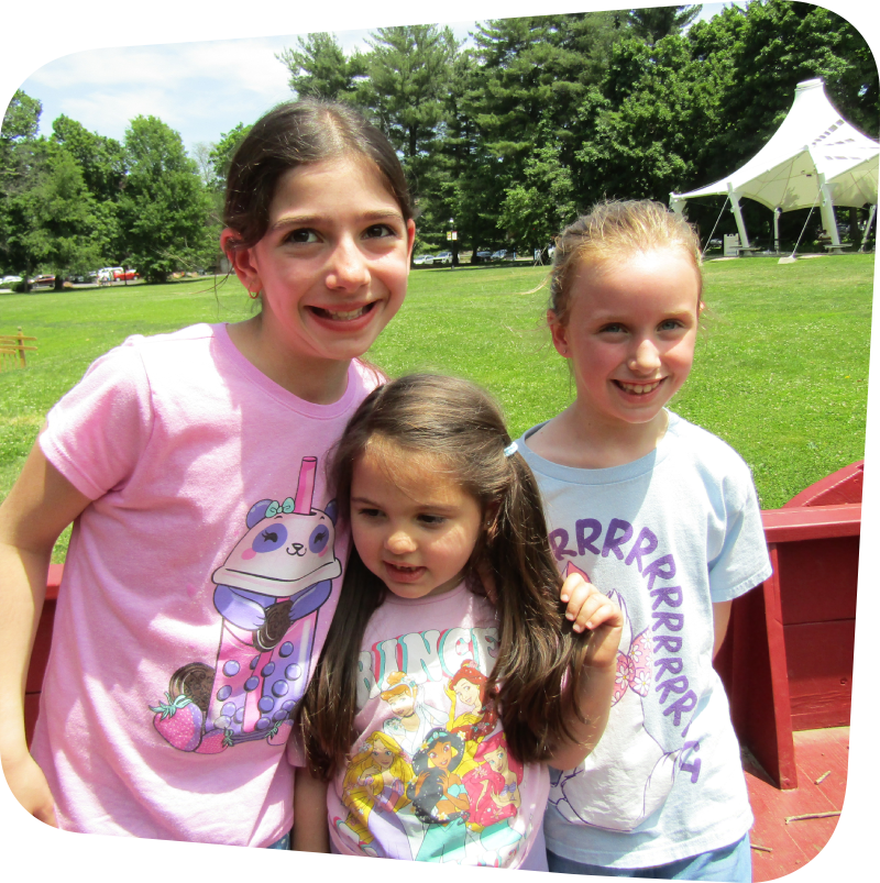 three girls in the wagon on the meadow at the Staten Island Children's Museum